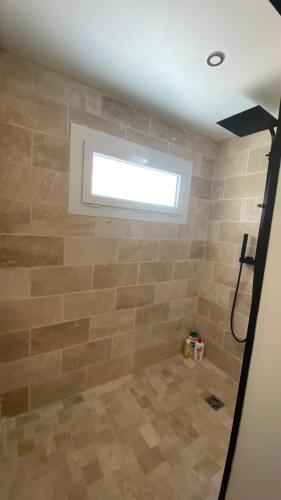 La salle de bains est pourvue d'un mur en pierre et d'une fenêtre. dans l'établissement La Léonardine à deux pas du château royal, à Amboise