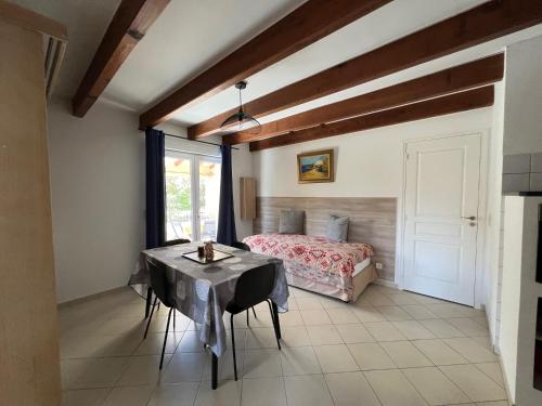 a bedroom with a bed and a table and a window at Résidence Casa Cintrone in Porto Pollo
