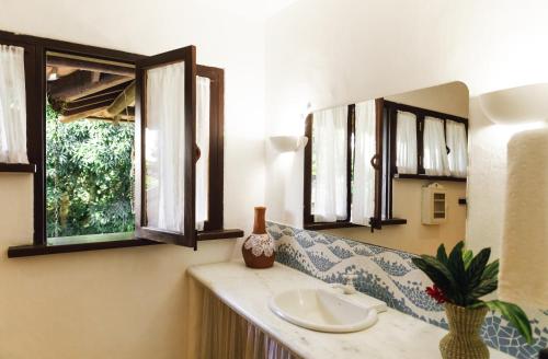 a bathroom with a sink and a mirror at Casa Baiana Pousada & Aconchego in Trancoso