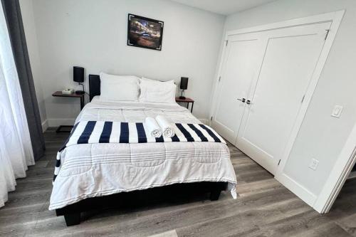 a bedroom with a bed with a black and white comforter at The Cozy Suite - 1BR with Free Parking in Paterson