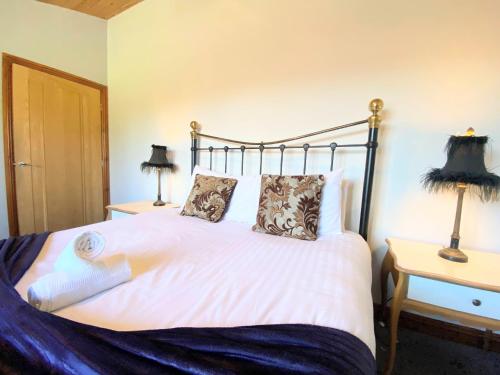 ein Schlafzimmer mit einem großen weißen Bett mit zwei Lampen in der Unterkunft Cleish 7 With Private Hot Tub - Fife - Loch Leven - Lomond Hills - Pet Friendly in Kelty