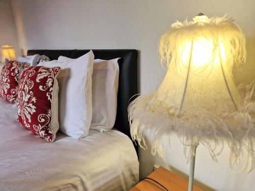 a bed with white pillows and a lamp on a table at Cleish 7 With Private Hot Tub - Fife - Loch Leven - Lomond Hills - Pet Friendly in Kelty