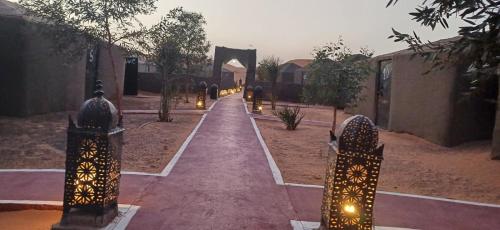 a walkway with lights in the middle of a street at Merzouga Camel Trekking Camp in Merzouga