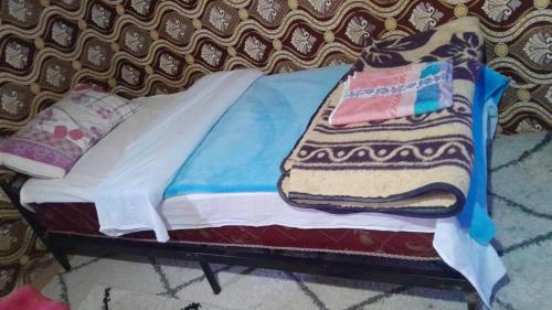 a small bed with towels on top of it at Merzouga Camel Trekking Camp in Merzouga