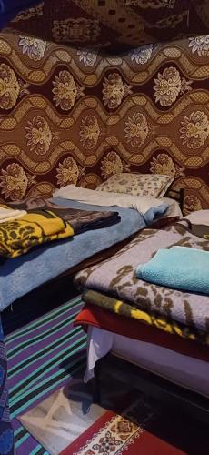 two beds sitting next to each other in a room at Merzouga Camel Trekking Camp in Merzouga