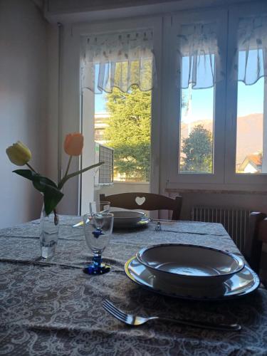 uma mesa de jantar com um prato e flores em Aviano Interno 3 em Aviano
