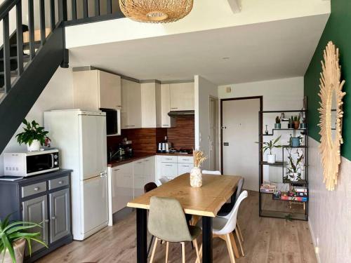 une cuisine avec une table en bois et une salle à manger dans l'établissement Appart vue port, proche océan, à Les Sables-dʼOlonne