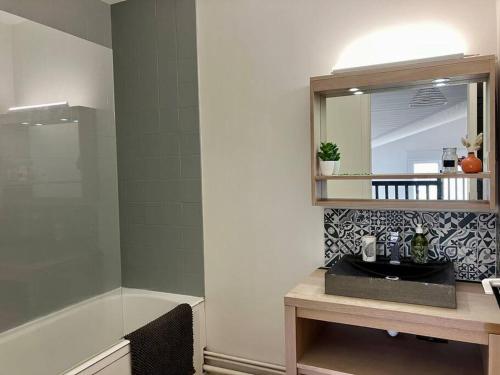 une salle de bain avec un lavabo, un miroir et une baignoire dans l'établissement Appart vue port, proche océan, à Les Sables-dʼOlonne