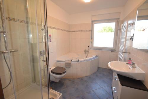 ein Badezimmer mit einer Badewanne, einem WC und einem Waschbecken in der Unterkunft Bliss Place - 1R Premium Apartment - Kingsize Bett, Smart TV, Küche, Balkon, Waschkeller in Magdeburg