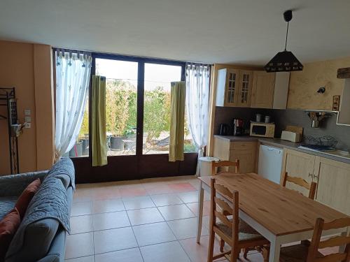 een woonkamer met een tafel en een keuken bij Le Mas Relax in Cavaillon