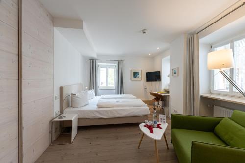 拜爾恩格里斯的住宿－弗徹斯巴拉酒店，一间卧室配有一张床和一张绿色沙发