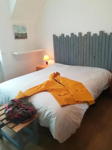 een bed met een oranje deken erop bij Nouelig bras in Loctudy