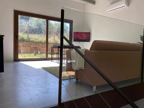 a living room with a couch and a glass door at Casa con piscina interior en Tamariu, Calella de Palafrugell in Palafrugell