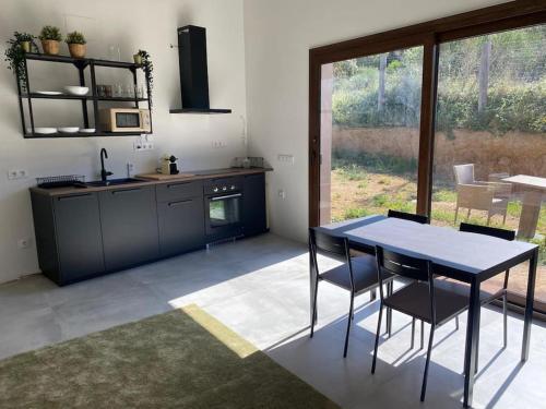 a kitchen with a table and chairs in a room at Casa con piscina interior en Tamariu, Calella de Palafrugell in Palafrugell
