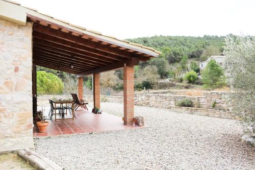 a pavilion with a table and chairs on a patio at Ca la Terra in Vallespinosa