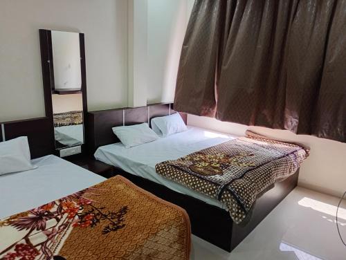 a room with two beds and a window at Hotel Barsana Palace, Near Mahakal Temple- 200 meter in Ujjain