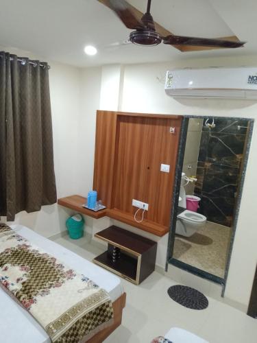 a room with a bathroom with a toilet and a mirror at Hotel Barsana Palace, Near Mahakal Temple- 200 meter in Ujjain
