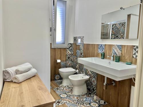 La salle de bains est pourvue d'un lavabo et de toilettes. dans l'établissement M'AMA apartment 2, à Ficarazzi