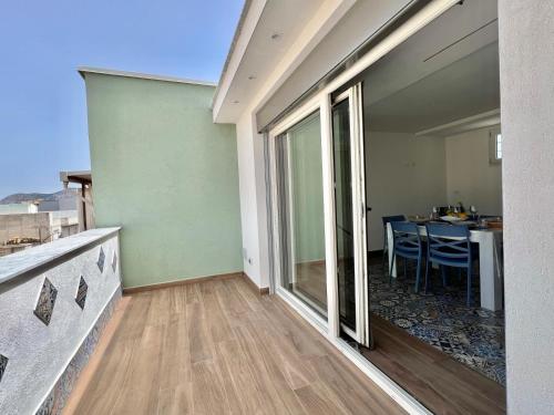 a room with a balcony with a table with chairs at M'AMA apartment 2 in Ficarazzi