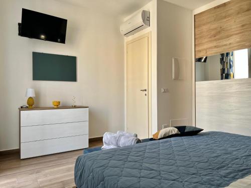 a bedroom with a bed and a dresser and a tv at M'AMA apartment 2 in Ficarazzi