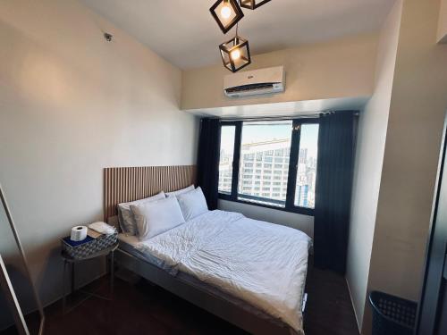 a small bed in a room with a window at Heart of Makati, Fully furnished condo, cbd central location in Manila