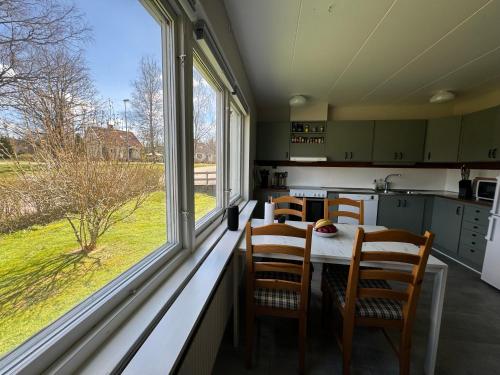 3bdr Family Friendly Villa 15 min from Ullared في Älvsered: مطبخ مع طاولة وكراسي بجوار نافذة