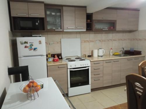 una cucina con piano cottura e frigorifero bianco di SIMENA Apartment a Kruševo