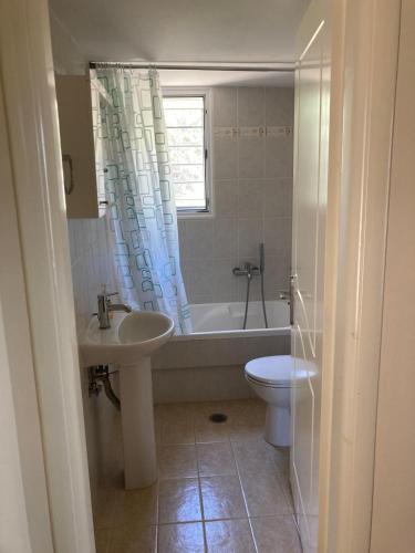 a bathroom with a tub and a sink and a toilet at Anaval's View Apartments in Kivérion