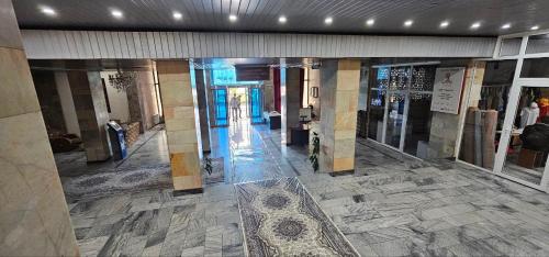 um corredor vazio num edifício com piso em azulejo em Dushanbe Hotel em Dushanbe