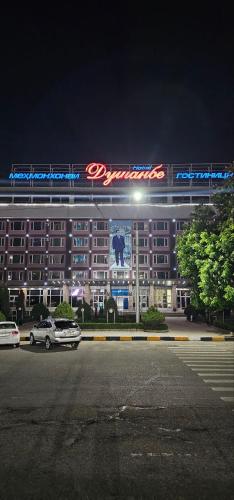 杜尚別的住宿－Dushanbe Hotel，一座大建筑,晚上有标志