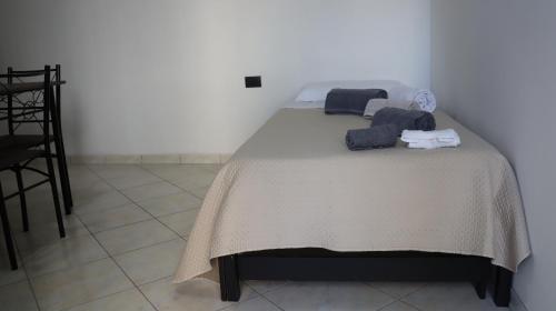 Una cama con toallas y toallas encima. en Il giardino di Mary, en Pompeya