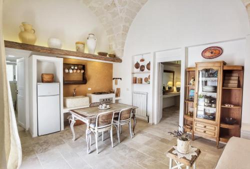 een keuken met een tafel en stoelen in een kamer bij Masseria Verbena suites in Macchia di Monte