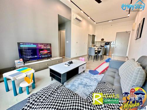 a living room with a couch and a tv at Amber Cove Impression City By Heystay Management in Melaka
