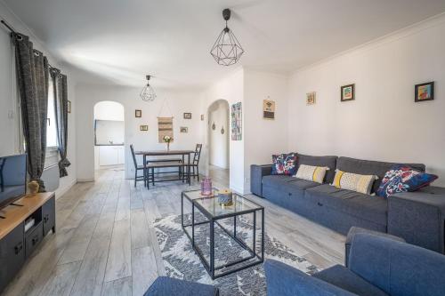 - un salon avec un canapé bleu et une table dans l'établissement Le Spacieux Anatole, T3 bis, centre ville Narbonne, à Narbonne