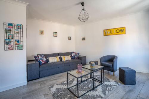 un salon avec un canapé et une table dans l'établissement Le Spacieux Anatole, T3 bis, centre ville Narbonne, à Narbonne