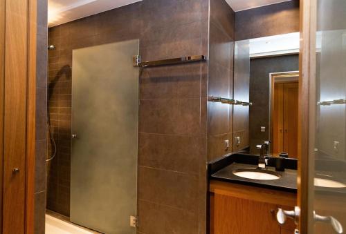 une salle de bain avec deux lavabos et une douche en verre dans l'établissement Appartement Annecy centre historique parking réservé, à Annecy