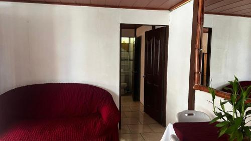 a living room with a red couch in a room at Casa Mar y Arena in Golfito