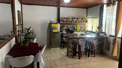 a kitchen with a counter and a table and a refrigerator at Casa Mar y Arena in Golfito