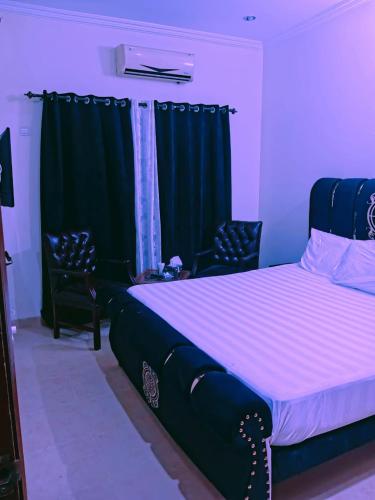 - une chambre avec un lit et deux chaises dans l'établissement Home Inn Guesthouse, à Islamabad