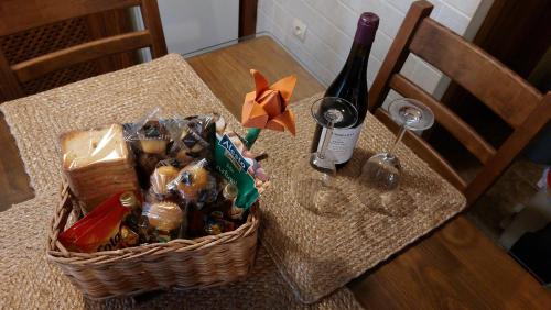 una cesta de comida y una botella de vino en una mesa en El Tinao de la Hiruela (Entremelojos) en La Hiruela