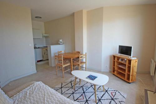 Il comprend un petit salon avec une table et une cuisine. dans l'établissement Le pompadour, à Limoges