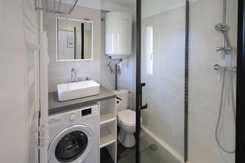 ein Badezimmer mit einer Waschmaschine und einem Waschbecken in der Unterkunft Studio tout équipé vue Port in La Grande-Motte