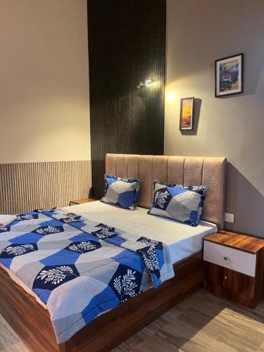 a bedroom with a bed with a blue and white comforter at Luxury apartment near expo in Greater Noida