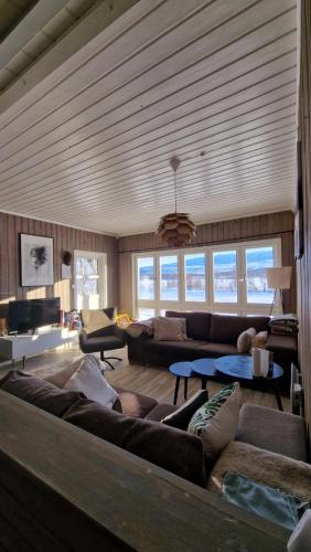 ein großes Wohnzimmer mit Sofas und einem Tisch in der Unterkunft Cosy cabin in North-Norway, Nearby Senja. in Sorreisa