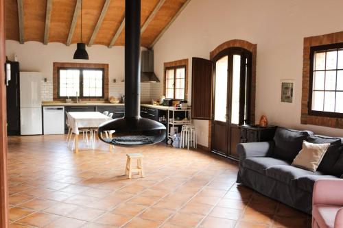 a living room with a stove in the middle of a room at Ca la Terra in Vallespinosa