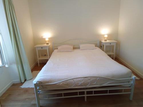 une chambre avec un lit avec deux tables de nuit et deux tables dans l'établissement La Calmille Maison avec Jardin, à Les Salelles