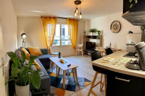 une cuisine et un salon avec un canapé et une table dans l'établissement Rouen Seine - Magnifique appart - Parking gratuit, à Rouen