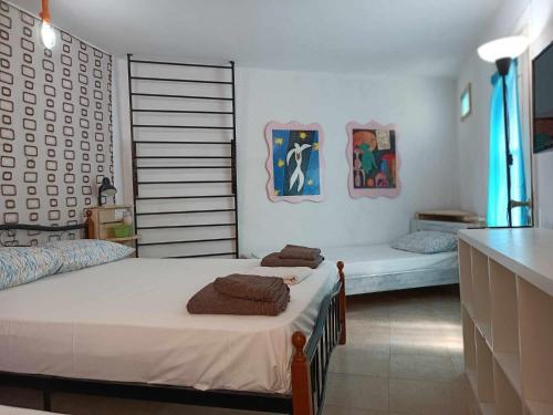 a bedroom with two beds with towels on them at BUENo in Skiathos Town