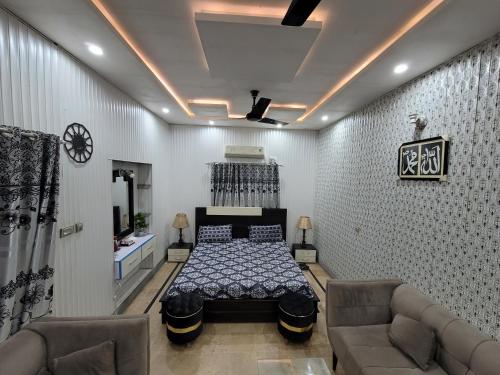 Harrys Guest House في Gujrānwāla: غرفة نوم بسرير واريكة في غرفة