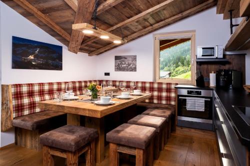 a kitchen with a wooden island with stools at Alpen Chalet Wohnung "Rosa" in Zellberg